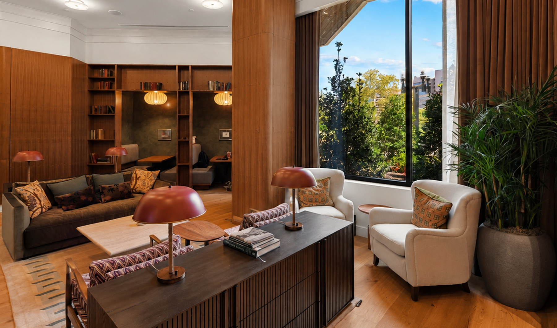 Cozy resident library area at Huxley featuring built-in bookshelves, comfortable seating, warm lighting, and floor-to-ceiling windows.