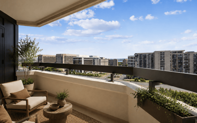 Private apartment balcony with outdoor seating and scenic views at Huxley Apartments in National Landing, Arlington, VA