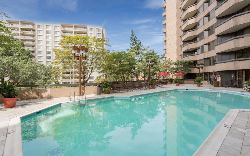a pool in a courtyard with buildings in the background
